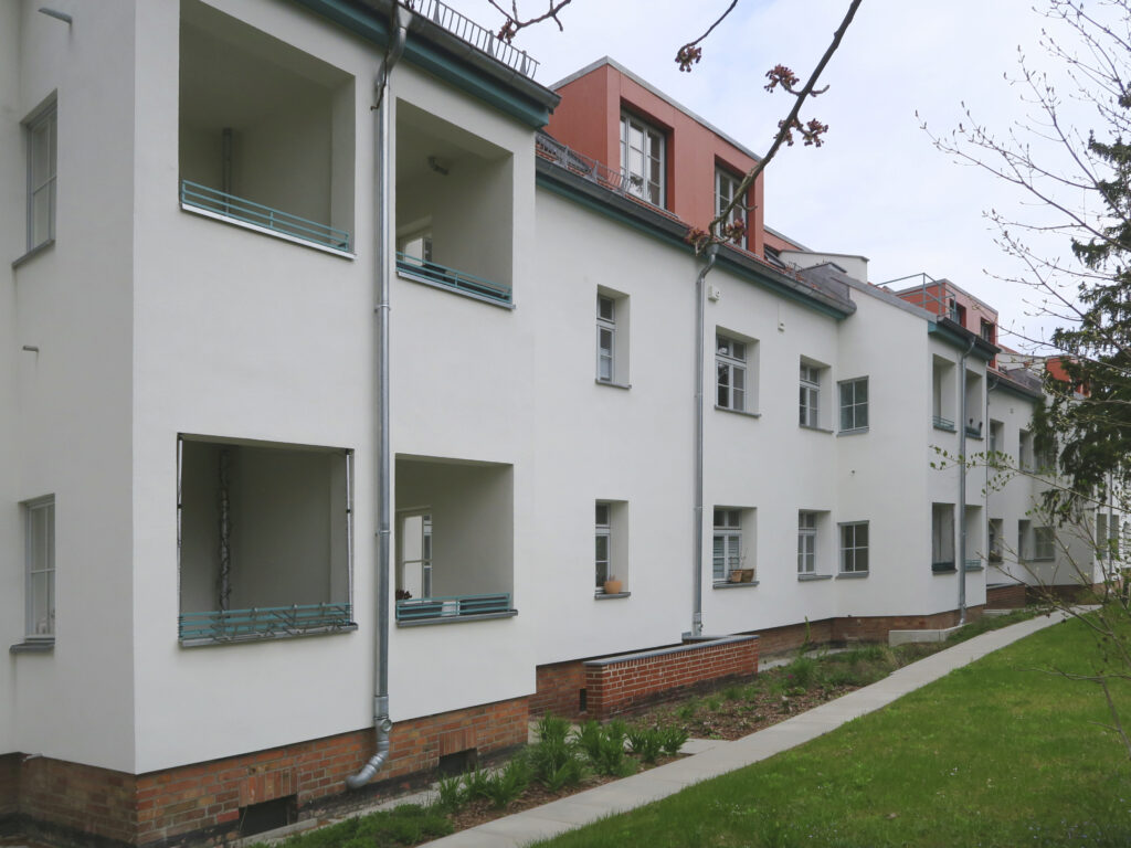 Blick in den Hinterhof der kleinteilig sanierten und behutsam aufgestockten zweigeschossigen Gebäude.
