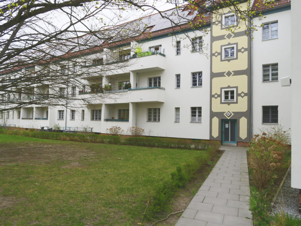 Blick auf die hofseitige Fassade mit Balkonen und einem aufwendig nach historischem Vorbild gestalteten Treppenhaus im Vordergrund.