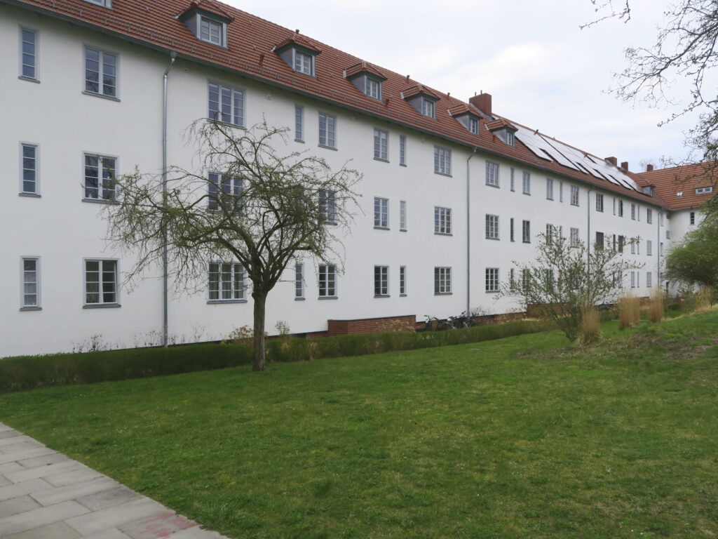Blick auf die hofseitige Fassade mit denkmalgerecht sanierten Fenstern und für Photovoltaik genutzten Dächern.